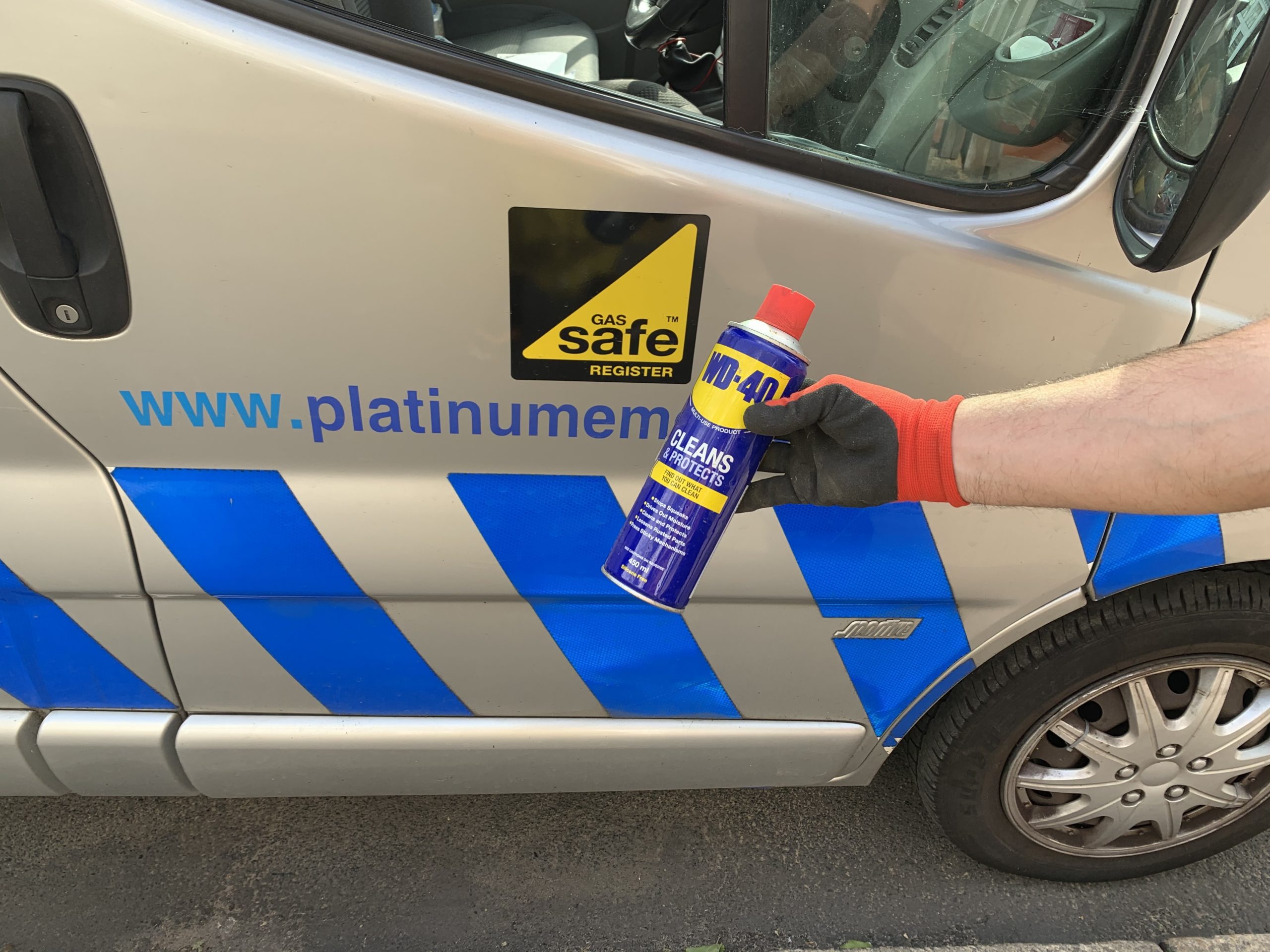 Photo with person holding can of WD40. In the background is website www.platinumemergency.com